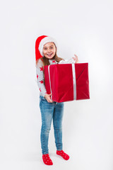 Smiling funny child in Santa red hat holding Christmas gift in hand. Christmas concept.