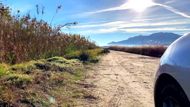 Car driving on a mud road, in the wetlands natural park La Marjal in Pego and Oliva, Spain