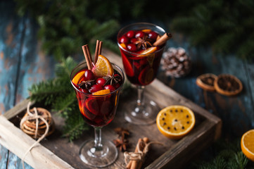 Christmas hot mulled wine in a glass with spices, citrus fruit and cranberry. Christmas atmosphere. 