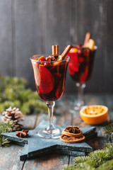 Christmas hot mulled wine in a glass with spices, citrus fruit and cranberry. Christmas atmosphere. 