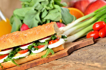 Bread sandwich with egg, arugula salad, tomatoes and radish