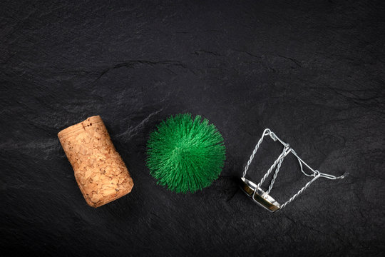 A Photo Of A Little Christmas Tree With A Champagne Cork And Closure, Shot From Above On A Black Background With Copy Space