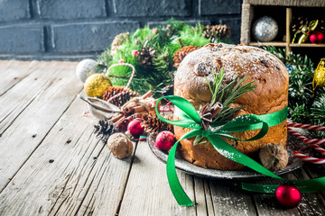 Traditional Christmas panettone with dried fruits and nuts, on old wooden background wth christmas decoration copy space top view