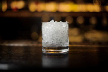 Cocktail glass of crushed ice standing on the bar stand