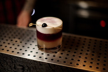 Glass of a New York sour cocktail on the steel bar counter