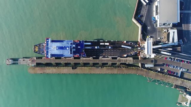Aerial top down view of ferry disembarking showing trucks lorries driving off this ship is merchant vessel used to carry passengers vehicles and cargo across the English channel 4k high resolution