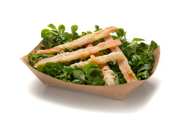 Fried snack sticks and salad in paper takeaway box