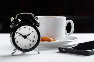 Still life , vintage alarm clock and coffee cup on white table