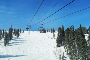 Cableway in mountains for skiers in ski resort. Chairlift in Sheregesh. Siberia, Russia.