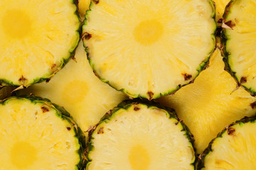 Pineapple juicy yellow slices background. Top view.