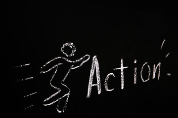 drawn in chalk on a black blackboard the symbol of the running man and the word action