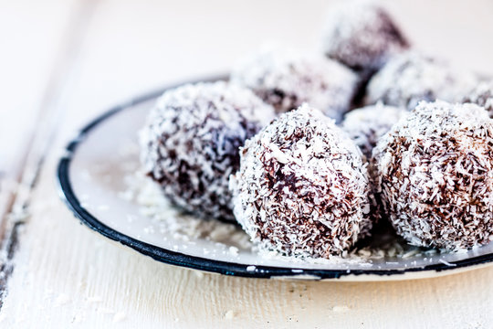 Lamington bliss balls with cashews, filled with raspberries, dark chocolate and coconut flakes