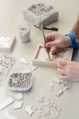 Hands Artist working on stones mosaic