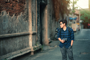Obraz na płótnie Canvas Happy Asian Traveler wearing Blue Plaid Shirt Walking to Travel with Film Camera in Bangkok , Thailand - Relax Lifestyle Travel in Hollidays