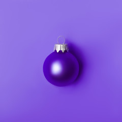 Christmas ball on Proton Purple. New Year greeting card with place for text.
