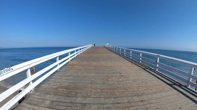 Paradise Cove Pier, a wooden pier in Paradise Cove beach, Malibu, California, United States. Luxurious destination on Pacific Coast. Summer blue sky