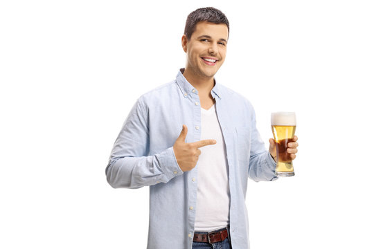 Handsome young man holding a pint of beer and pointing at it