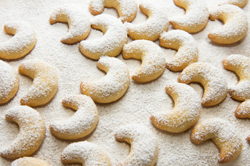 German and Austrian traditional Christmas cookies vanilla crescents on white tray powdered with...