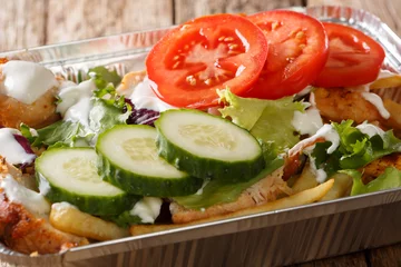  Recipe Dutch fast food kapsalon of french fries, chicken, fresh salad, cheese and sauce close-up. horizontal © FomaA