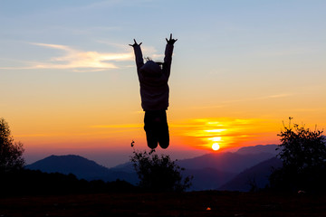 Silhouette of happy child jumping playing on mountain at sunset or sunrise time for 2019