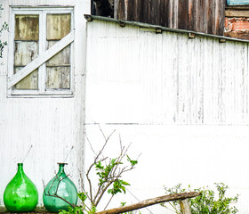 countryside white shack with two large glass bottles on the left corner