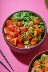 Poke bowl with marinated salmon and vegetable salad on rice