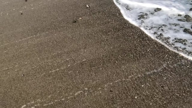 Background shot of sand with a wave washing over it and then pulling away. Perfect to use as a background and leave a hidden message.