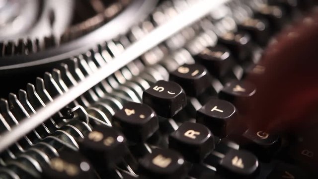 Close up of human hands using vintage typewriter machine selective focus on keyboard