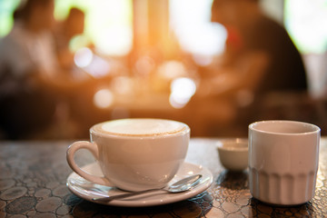 Hot art Latte Coffee in a cup on wooden table in Coffee shop blur background. business time and coffee break.