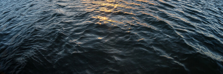 Fototapeta premium Water waves and orange sun light reflection