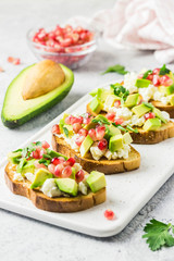 Avocado feta cheese pomegranate seeds crostini. Selective focus, space for text.