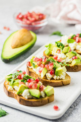 Avocado feta cheese pomegranate seeds crostini. Selective focus, space for text.