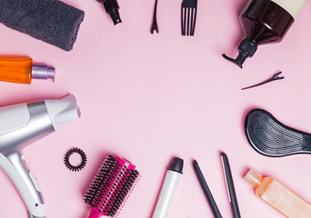 Hair styling and care items and products on pink background
