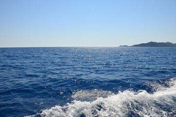 Shining blue Mediterranean sea. View from the yacht. Foamy waves on the water.