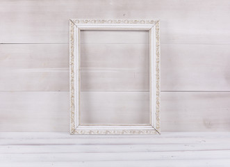 white elegant baroque frame on a white wooden table