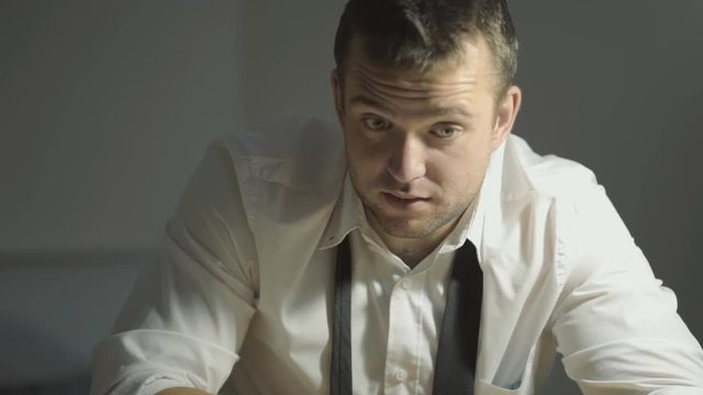 The guy detective in a white shirt listens to the interlocutor with a surprised face in his office