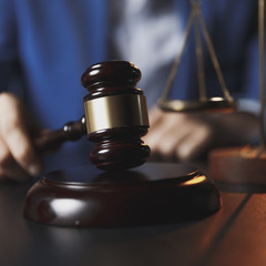 justice and law concept.Male lawyer in the office with brass scale on wooden table,reflected