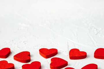 Red wooden hearts on white textured background with copy space. Symbol of love and Valentine's day