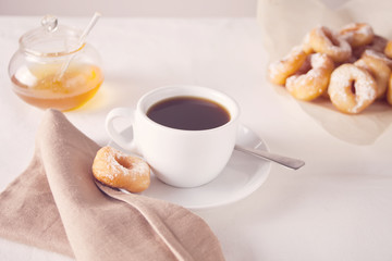 Fresh mini donuts with cup of coffee on the table