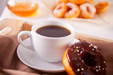 Fresh donuts with cup of coffee on the wooden table