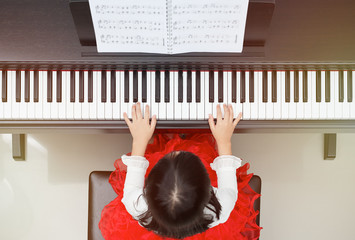 Little asian girl learning to play piano