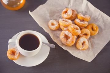 Fresh mini donuts with cup of coffee on the wooden table
