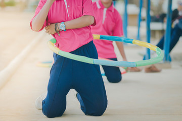 Female students doing exercise with a hula-hoop for a good healt