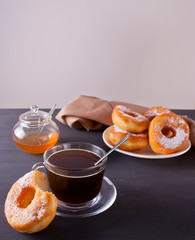 Fresh donuts with cup of coffee on the wooden table