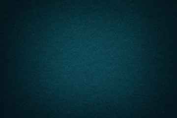 Texture of old dark blue paper background, closeup. Structure of dense deep bluish cardboard.