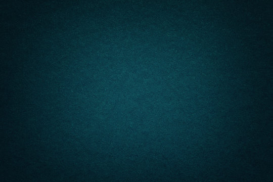 Texture of old dark blue paper background, closeup. Structure of dense deep bluish cardboard.