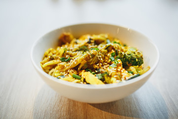 Warm salad with chicken, vegetable and sesame seeds. Close up