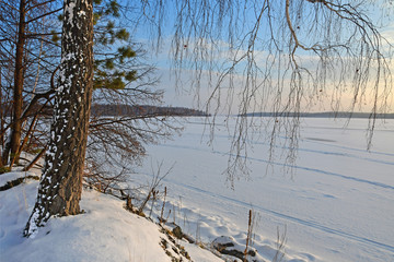 The shore of Vyazovy island and frozen lake Uvildy in Chelyabinsk region in winter in cloudy weather. Russia
