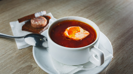 Ukrainian traditional borsch. Russian vegetarian red soup in white bowl on red wooden background. Top view. Borscht, borshch with beet