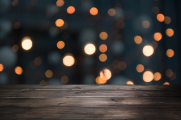 Blurred gold garland and wooden tabletop as foreground. Image for display your christmas products.
